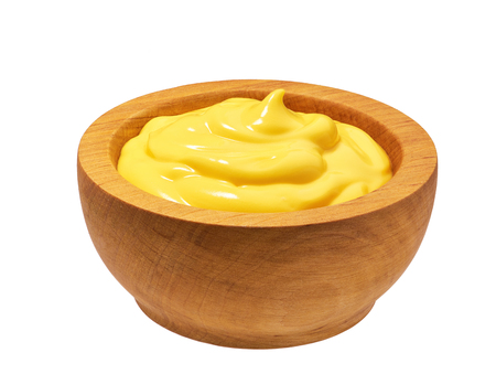 Wooden bowl with cheese sauce  isolated on white backgroundの写真素材