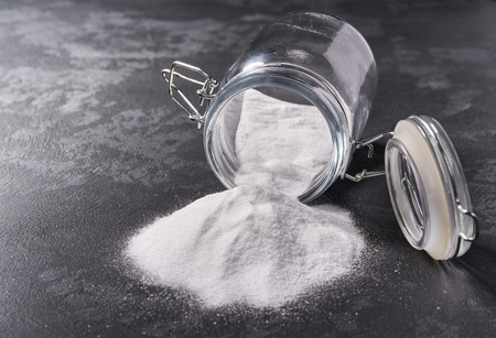 Jar of baking soda on a black background