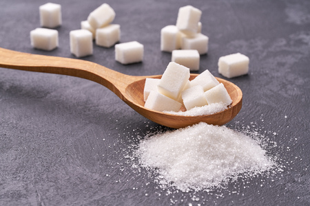 white sugar in wood spoon on black table,selective focus