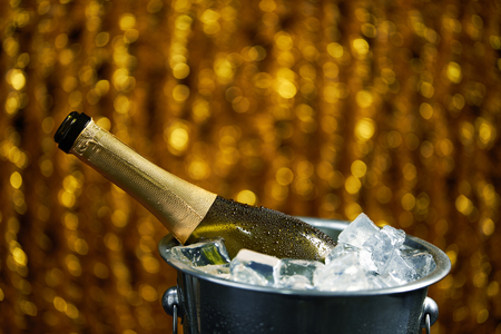 bottle of champagne in a bucket with ice on Christmas and New Years holiday backgroundの写真素材
