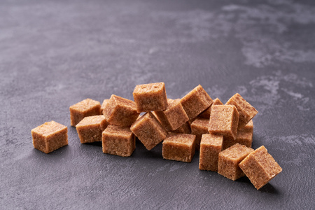 Brown sugar cubes  on black table close-up.の写真素材