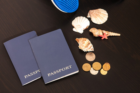 Passport, money, shells and Slippers are on the table.の写真素材