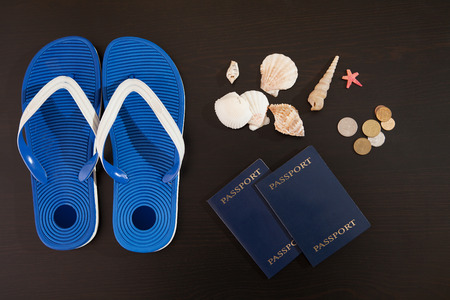 Passport, money, shells and Slippers are on the table.の写真素材