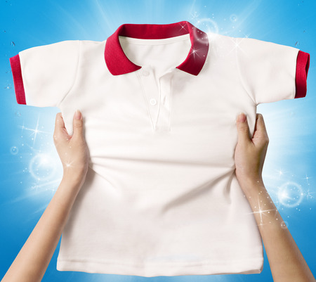 Hands holding a white clean shirt の写真素材