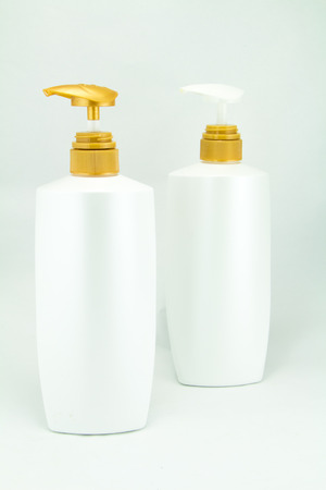 White plastic bottles for cosmetic creams, lotions, shampoo and gels with colored capsの写真素材