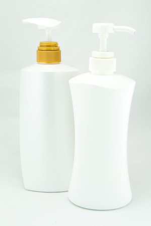 White plastic bottles for cosmetic creams, lotions, shampoo and gels with colored capsの写真素材