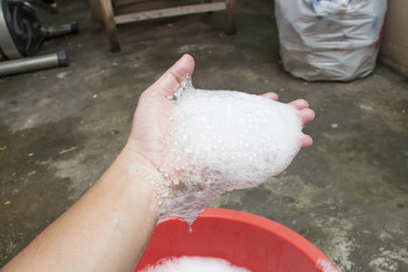 Hand washing clothes with soapy waterの写真素材