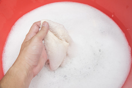 Hand washing clothes with soapy waterの写真素材
