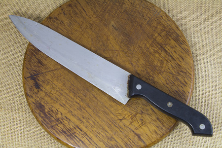 Knife on wooden block with sack background
