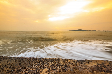 Sunrise at dawn with gentle waves.の写真素材