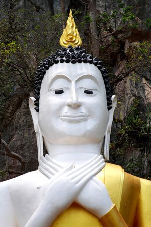 Thai Buddha statue stands on the cliffの写真素材