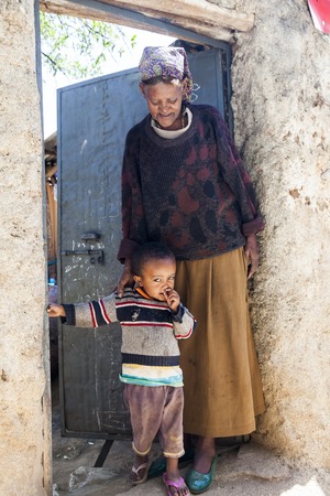 HARAR, ETHIOPIA - DECEMBER 24, 2013  Unidentified grandmother with grandchild posing in the entrance of their house in ancient walled city of Jugol, that daily life is almost unchanged in more than four hundred years のeditorial素材