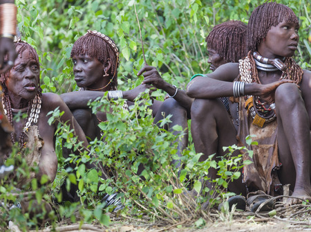 TURMI, OMO VALLEY, ETHIOPIA - DECEMBER 30, 2013: Unidentified women get ready for dancing at bull jumping ceremony. Jumping of the bull is a rite of passage into manhood in some Omo Valley tribes.のeditorial素材