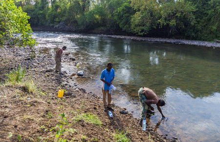 MAGO NATIONAL PARK OMO VALLEY ETHIOPIA  JANUARY 01 2014: People draw water from the Mago River to bottles. Water is a treasure in Africa.のeditorial素材