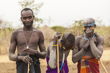 MAGO NATIONAL PARK OMO VALLEY ETHIOPIA  JANUARY 01 2014: Unidentified boys and a man from Mursi...