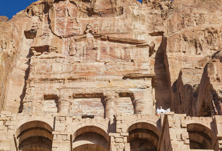 PETRA, JORDAN - OCTOBER 28, 2014: Unidentified local men dressed in white in front of the Urn Tomb.のeditorial素材