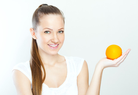 Portrait of a young beautiful woman with orangeの写真素材