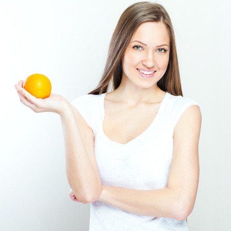 Portrait of a young beautiful woman with orangeの写真素材