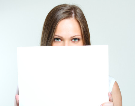 portrait of a beautiful young happy woman holding blank poster  empty copyspace for ads の写真素材