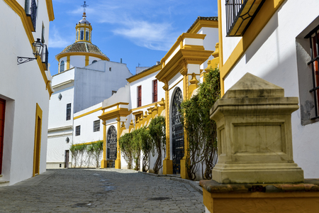 white with yellow decorated houses in the old streets of Seville, Spainの写真素材