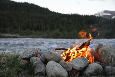 small campfire on the banks of a river between stonesの写真素材