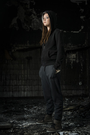 Portrait of a young girl standing in a house what has been destroyed by fireの写真素材