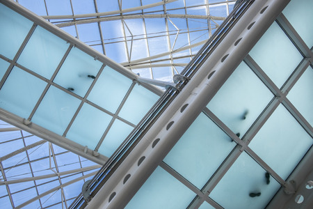 modern office building with diagonal crossing transparent bridges  with footprints from people standing on it.の写真素材
