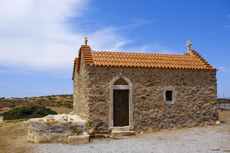 small church with orange tiles standing in a deserted landscape on the island of Crete Greeceの写真素材