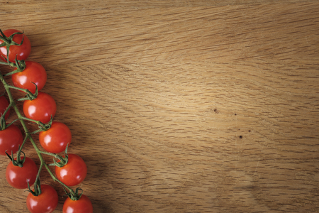 Food and cooking concept - cherry tomatoes on wood background with copy spaceの写真素材