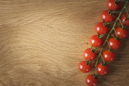 Food and cooking concept - cherry tomatoes on wood background with copy spaceの写真素材