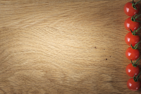 Food and cooking concept - cherry tomatoes on wood background with copy spaceの写真素材