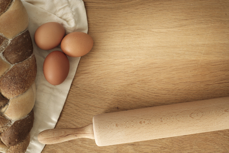 bread with eggs and rolling pin on a wooden table with copy space, food conceptの写真素材