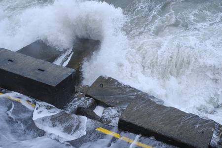 High waves caused by a heavy storm hit the quayside and destroy a paved road thereの写真素材
