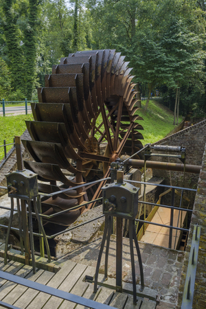 Old historically large rusted metal blade wheel of a water millの写真素材