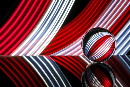 glass/crystal ball reflecting light streaks of color red and whiteの写真素材
