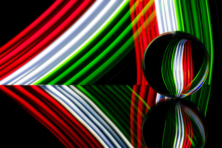 glass/crystal ball reflecting light streaks of color red, white, blue and green.の写真素材