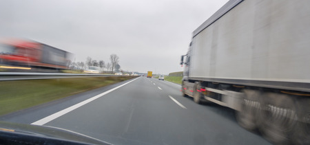 Lorries overtaking at high speed on the highway, with movementの写真素材