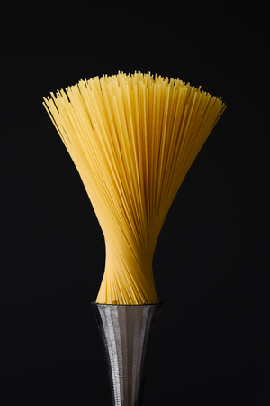 spaghetti pasta as a modern design artwork on a steel pedestal and resembling a brush, food concept.の写真素材