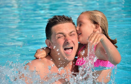 Father and daughter playing in the pool.の写真素材