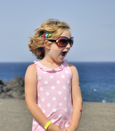 Little girl in sunglasses on the beach.の写真素材