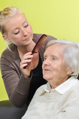 Senior woman with her caregiver in home の写真素材