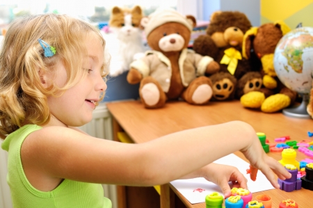 Little girl painting hands in her room の写真素材