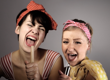 Two women singing together  Karaoke, retro style の写真素材