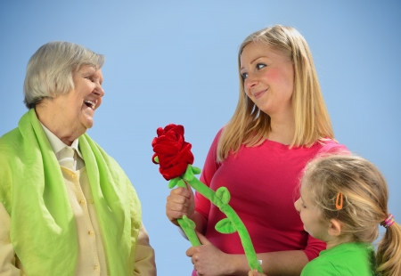 Child and grandchild give a gift their grandmother, expressing his care and love for her の写真素材