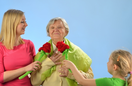 Child and grandchild give a gift their grandmother, expressing his care and love for her の写真素材