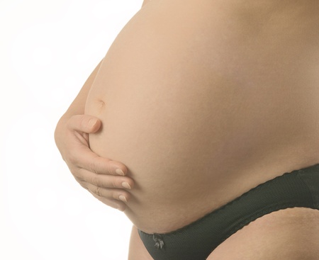Pregnant woman with hands over tummy at white background の写真素材