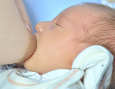 Newborn baby sucks motherの写真素材