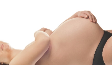 Pregnant woman with hands over tummy at white background の写真素材
