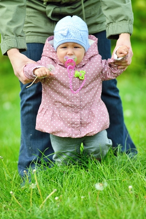 Baby learns to walk in the grass の写真素材