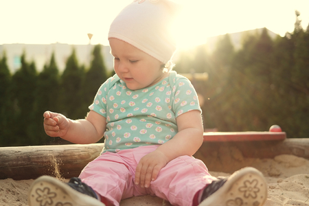Cute baby on grass in sandbox の写真素材
